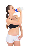 Toned woman in sportswear drinking water