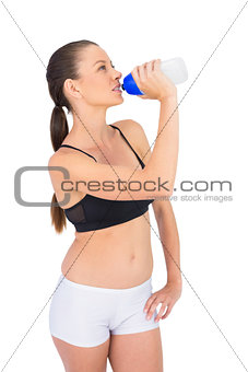 Toned woman in sportswear drinking water