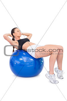 Serious fit woman working out with exercise ball