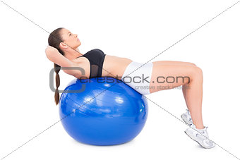 Concentrated fit woman working out with exercise ball