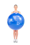 Relaxed fit woman holding exercise ball in front of her