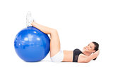 Smiling fit woman developing her abs using exercise ball