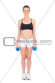 Smiling fit woman holding dumbbells