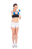Cheerful fit woman working out with dumbbells