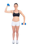 Happy fit woman exercising with dumbbells