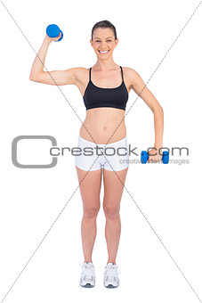 Happy fit woman exercising with dumbbells