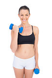 Smiling woman lifting dumbbell