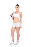 Peaceful fit sportswoman holding skipping rope around neck