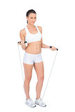 Fit woman in sportswear exercising with skipping rope