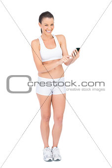 Smiling woman tiping on phone looking at camera