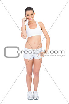 Smiling woman in sportswear on the phone