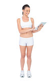 Smiling fit woman using tablet