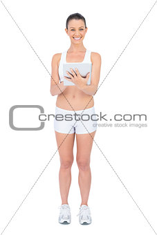 Cheerful fit woman using tablet computer