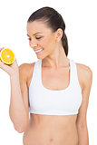 Smiling woman holding orange slice