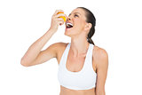 Sporty woman drinking juice from orange