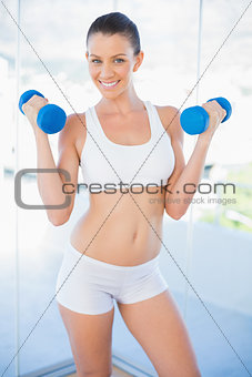 Smiling woman lifting dumbbells