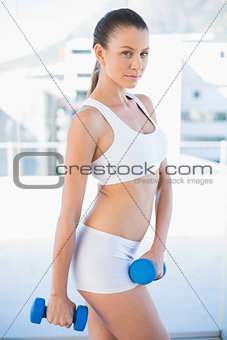 Fit woman working out with dumbbells