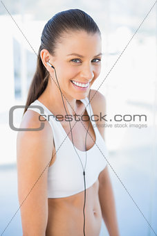 Laughing woman in sportswear listening to music
