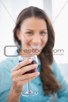 Smiling gorgeous brunette holding glass of red wine