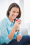 Happy gorgeous brunette holding glass of red wine