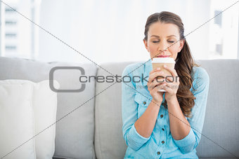 Delighted woman holding cup of coffee