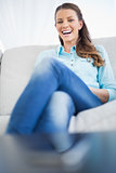 Attractive cheerful woman sitting on sofa