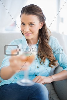 Smiling woman showing glass of white wine