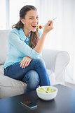 Smiling attractive woman eating healthy salad