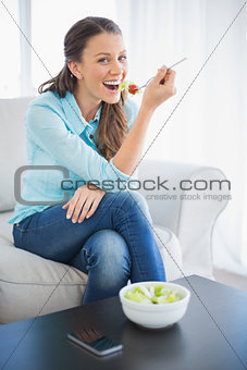 Smiling attractive woman eating healthy salad