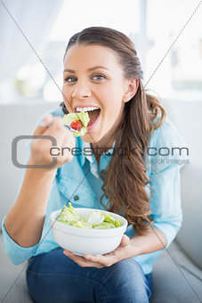 Happy attractive woman eating healthy salad