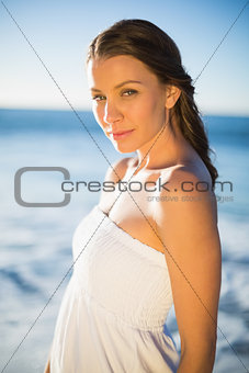 Peaceful brunette in white summer dress posing