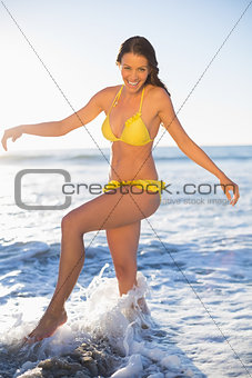 Happy gorgeous woman in yellow bikini having fun in the sea