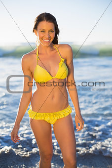 Cheerful gorgeous woman in yellow bikini bathing in the sea