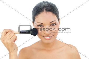 Pretty black haired model applying blusher