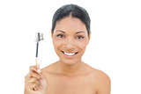Smiling black haired model holding eyebrow brush