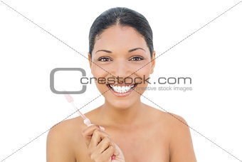 Cheerful black haired model holding toothbrush
