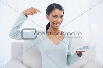Cheerful attractive woman pointing at her laptop