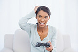 Irritated woman sitting on sofa playing video games