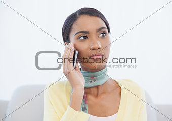 Cheerful elegant woman sitting on sofa having a phone call