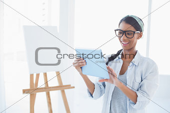 Cheerful attractive artist using her tablet pc