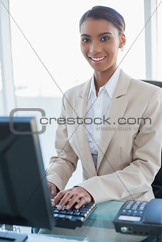 Cheerful businesswoman working on her computer