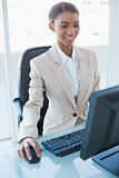 Cheerful attractive businesswoman working on her computer