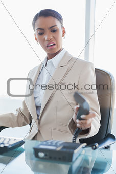 Furious elegant businesswoman hanging up the phone
