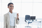Smiling elegant businesswoman holding cup of coffee