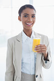 Smiling elegant businesswoman holding glass of orange juice