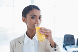 Smiling elegant businesswoman drinking orange juice
