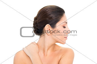 Brunette turning her head to the right with hand on shoulder
