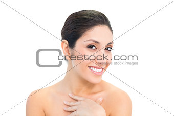 Smiling brunette looking at camera with hand on chest