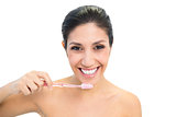 Brunette holding toothbrush and smiling at camera