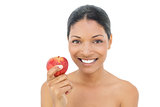 Smiling black haired model holding red apple